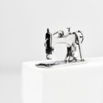 a small sewing machine on a white block