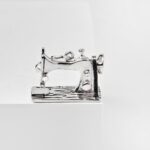 a silver sewing machine on a white surface