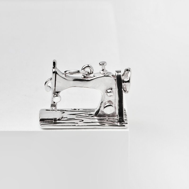 a silver sewing machine on a white surface