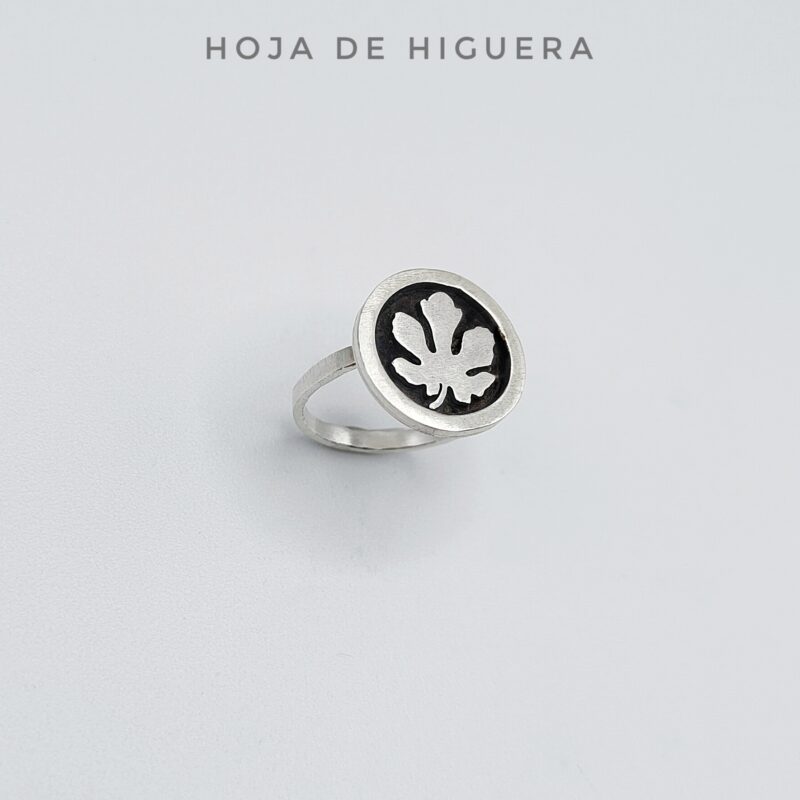 a silver ring with a black circle with a flower on it