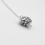 a silver necklace with a brain pendant