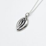 a silver necklace with a seed on it