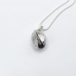 a silver oval pendant on a chain