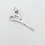 a silver scissors on a white surface