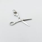 a silver scissors on a white surface