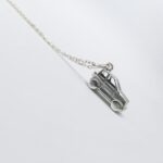 a silver car necklace on a chain