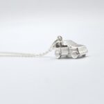 a silver car pendant on a chain