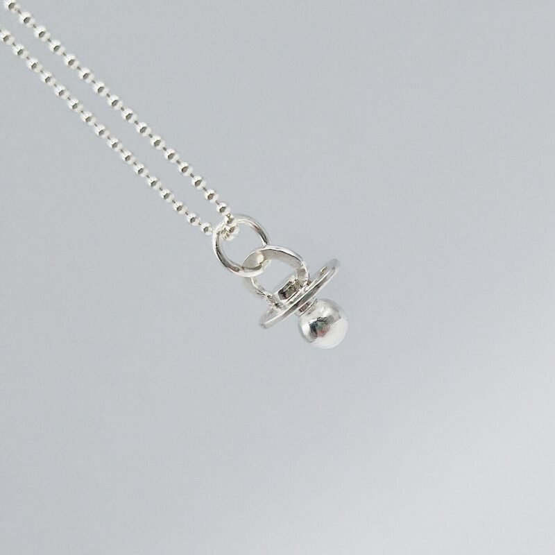 a silver necklace with a pacifier